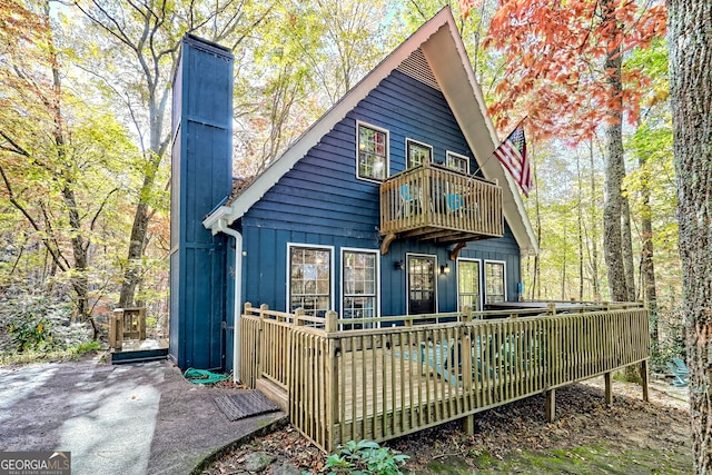 rear view of property with a balcony and a deck