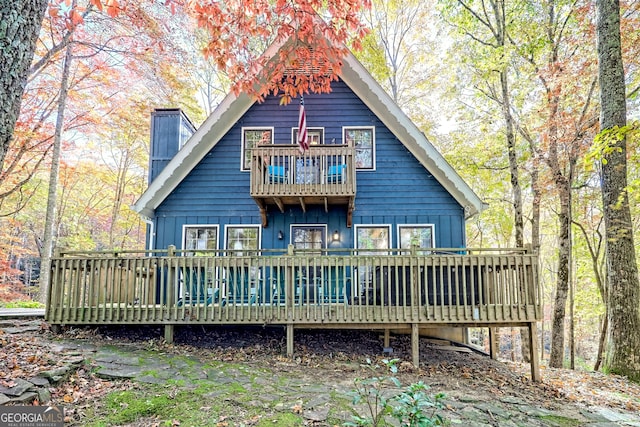 back of property with a deck and a balcony