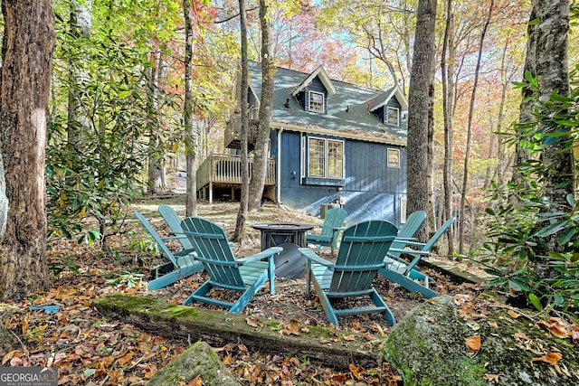 rear view of property with a fire pit