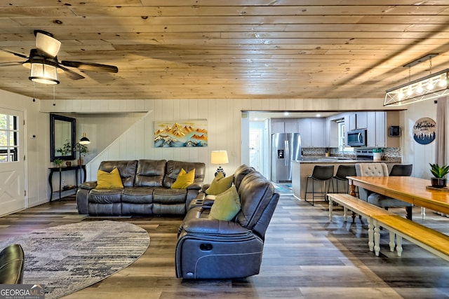 living room with wood ceiling, hardwood / wood-style flooring, wooden walls, and ceiling fan