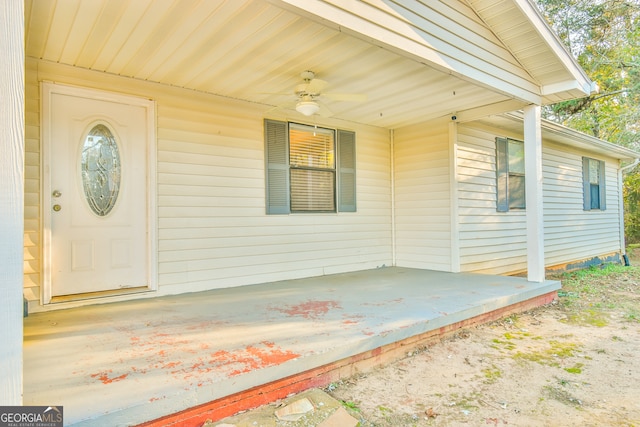 view of exterior entry featuring ceiling fan and a porch