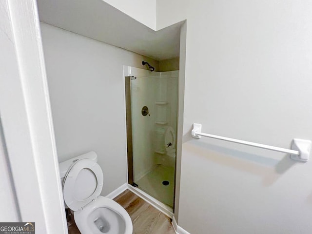 bathroom with toilet, walk in shower, and wood-type flooring