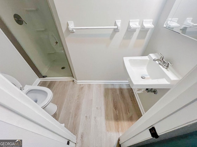 bathroom with sink, hardwood / wood-style flooring, toilet, and walk in shower