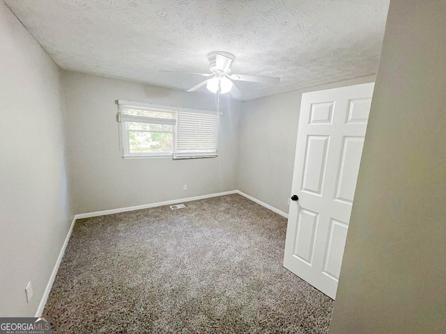 carpeted empty room featuring ceiling fan and a textured ceiling