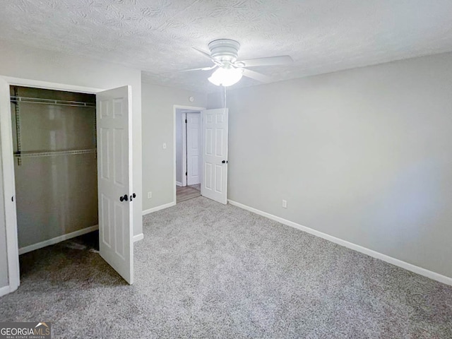 unfurnished bedroom featuring a closet, ceiling fan, carpet flooring, and a textured ceiling