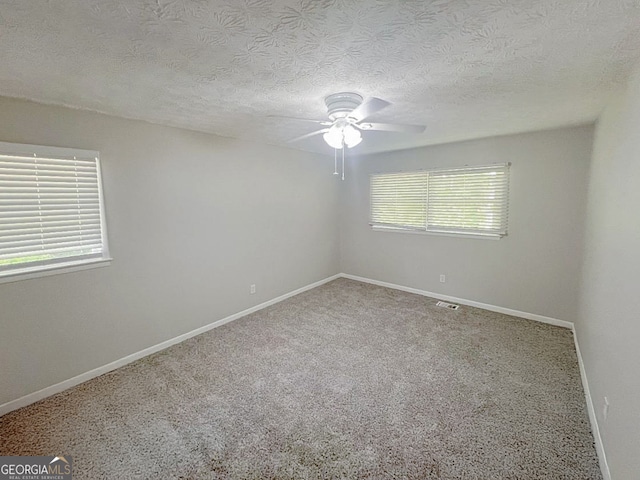 unfurnished room with ceiling fan, a textured ceiling, and carpet floors