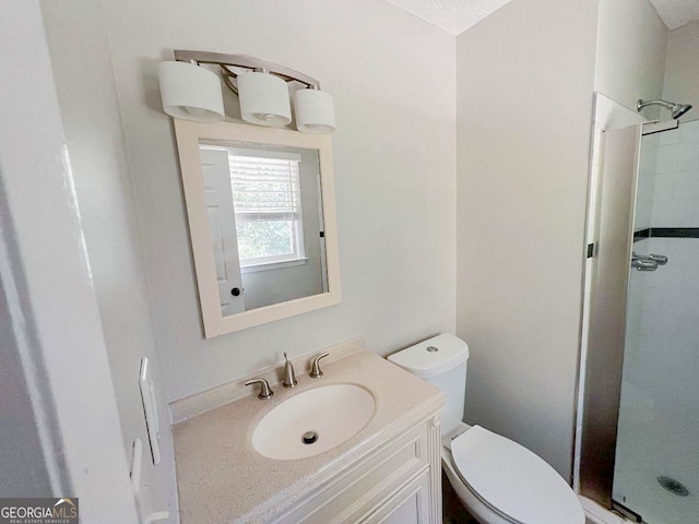 bathroom with toilet, vanity, and a shower with door