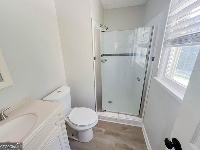 bathroom with vanity, a shower with shower door, hardwood / wood-style flooring, and toilet