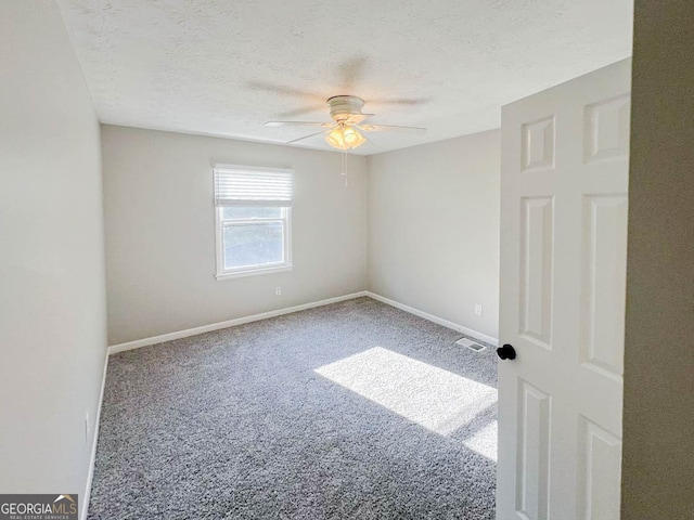 unfurnished room featuring a textured ceiling, carpet, and ceiling fan