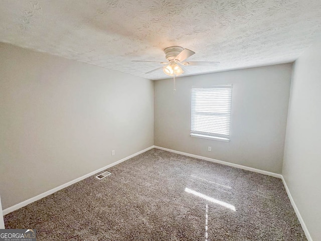 spare room featuring ceiling fan, carpet, and a textured ceiling