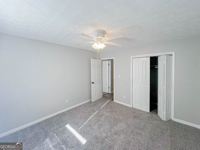 unfurnished bedroom with a closet, ceiling fan, a textured ceiling, and carpet floors