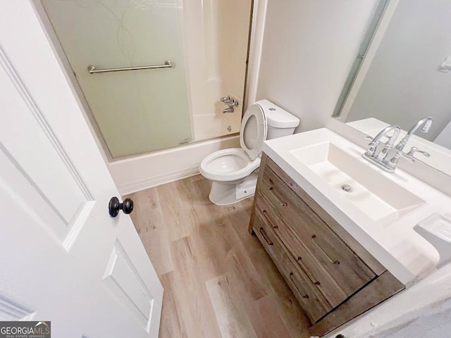 full bathroom with vanity, toilet, enclosed tub / shower combo, and hardwood / wood-style floors