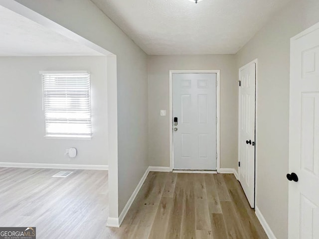 interior space with a textured ceiling and light hardwood / wood-style floors