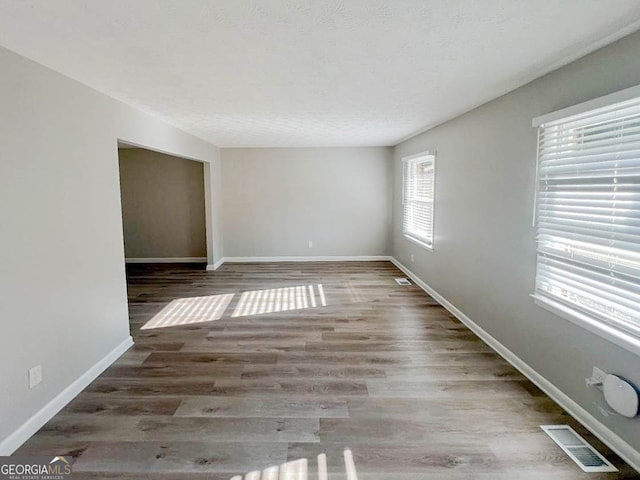 unfurnished room featuring a textured ceiling and hardwood / wood-style flooring