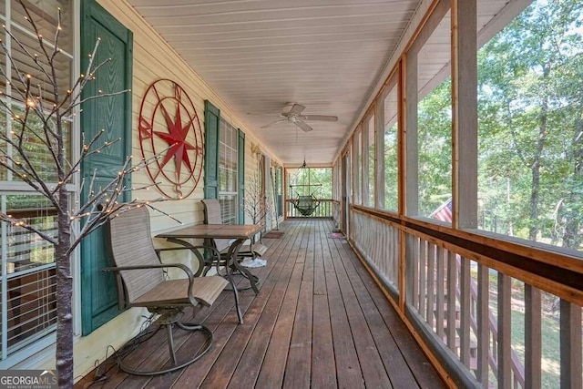 unfurnished sunroom featuring ceiling fan