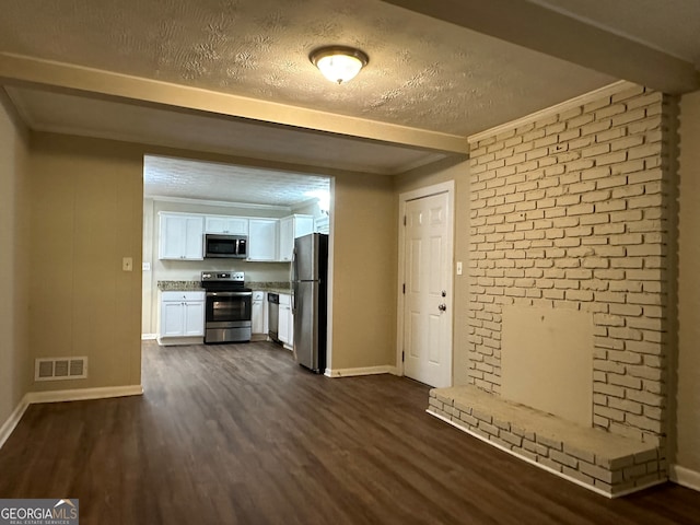 kitchen with crown molding, white cabinetry, appliances with stainless steel finishes, a textured ceiling, and dark hardwood / wood-style flooring