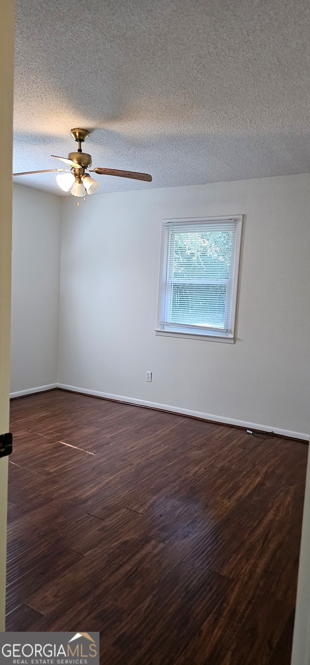 spare room featuring a textured ceiling, dark hardwood / wood-style floors, and ceiling fan