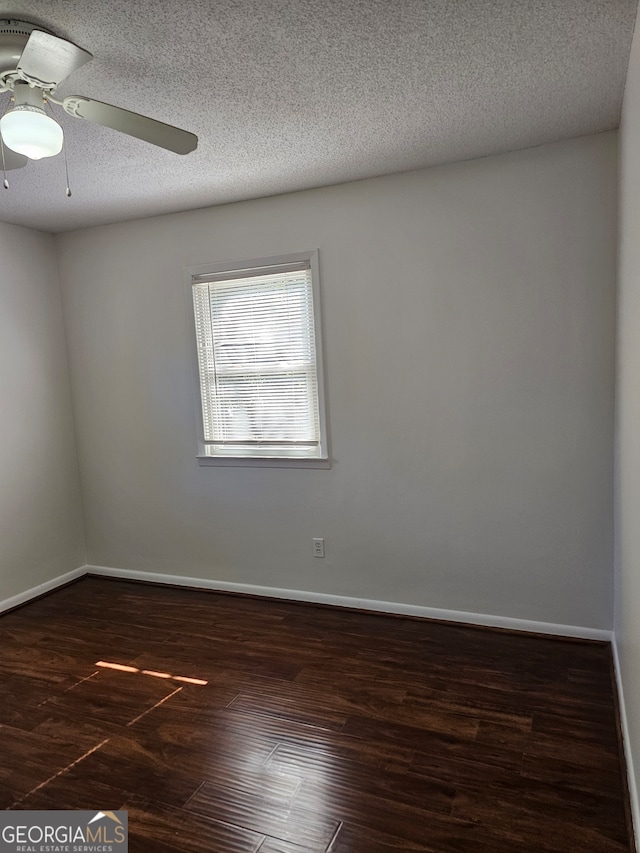 empty room with ceiling fan, a textured ceiling, and dark hardwood / wood-style flooring