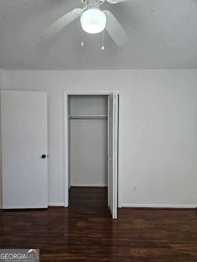 unfurnished bedroom with a closet, dark hardwood / wood-style floors, a textured ceiling, and ceiling fan