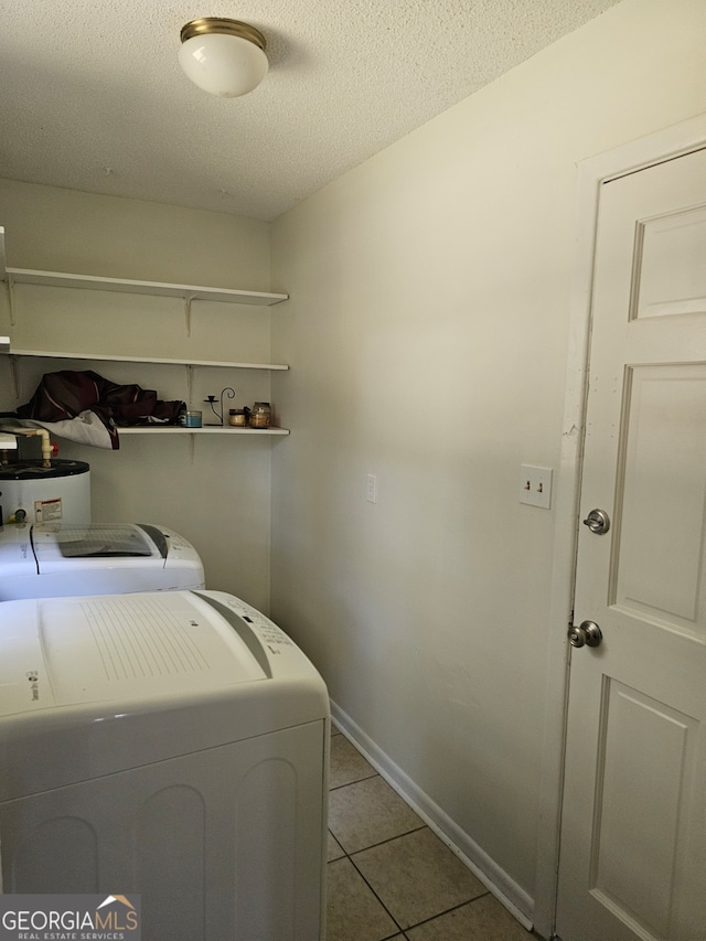 laundry area with a textured ceiling, water heater, washing machine and clothes dryer, and light tile patterned floors