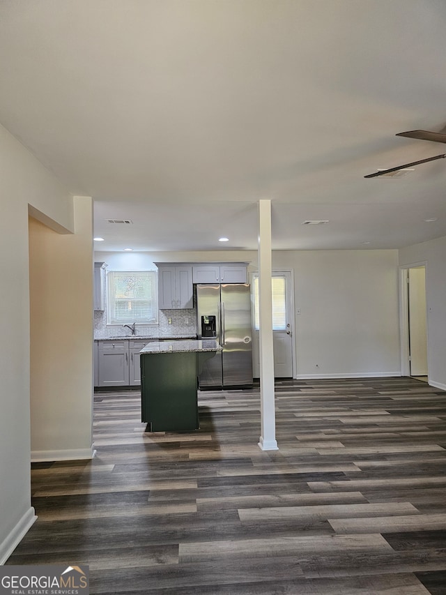 kitchen featuring dark wood-type flooring, tasteful backsplash, stainless steel fridge with ice dispenser, and gray cabinets