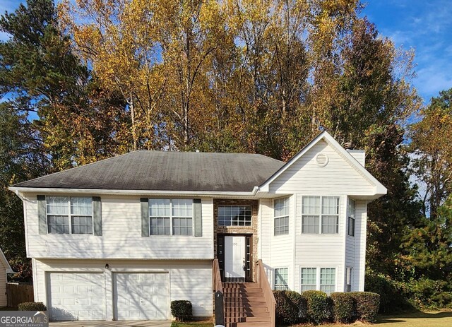 split foyer home with a front lawn and a garage