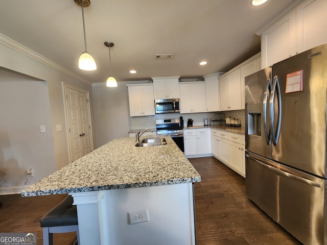 kitchen featuring white cabinets, dark hardwood / wood-style flooring, a kitchen island with sink, pendant lighting, and stainless steel appliances