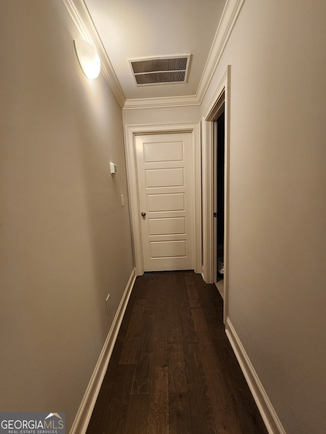 corridor with dark wood-type flooring and crown molding