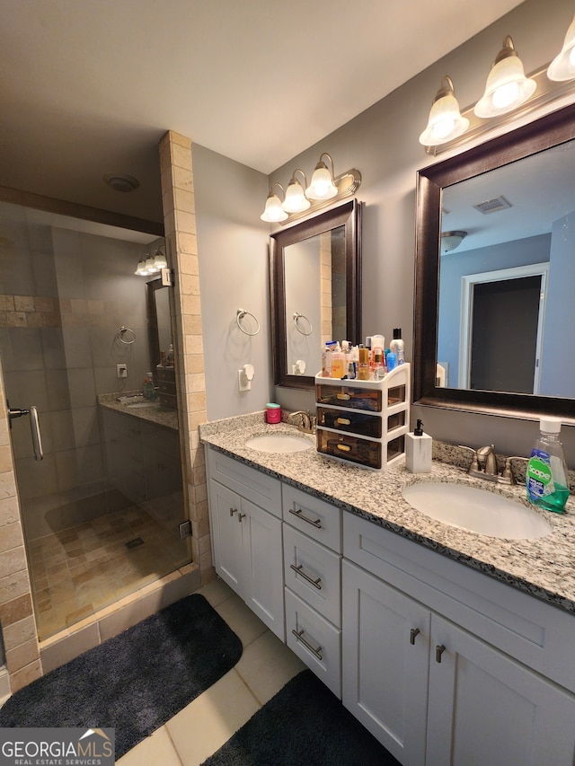 bathroom with vanity, a shower with shower door, and tile patterned flooring