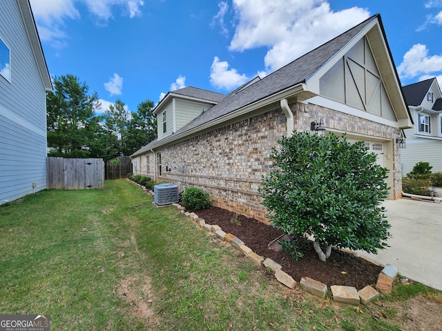 view of property exterior with central air condition unit, a garage, and a lawn