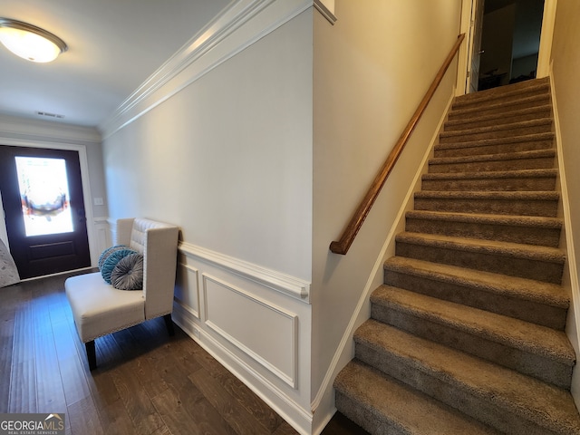 entryway with ornamental molding and dark hardwood / wood-style floors