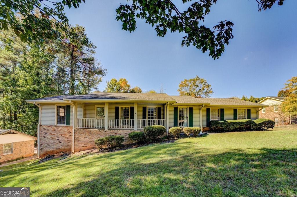 ranch-style house featuring a porch and a front lawn