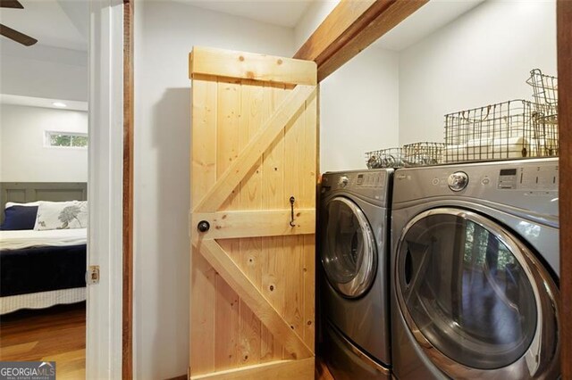 clothes washing area with washing machine and clothes dryer, wood finished floors, laundry area, and ceiling fan