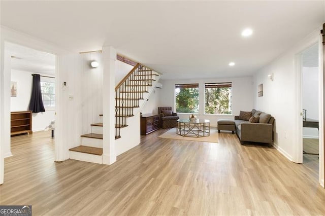 living room featuring baseboards, recessed lighting, light wood-style floors, and stairway