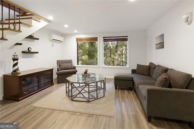 living area featuring stairs, wood finished floors, a wall mounted AC, baseboards, and recessed lighting