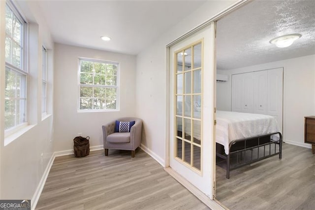 living area with light hardwood / wood-style flooring and a textured ceiling