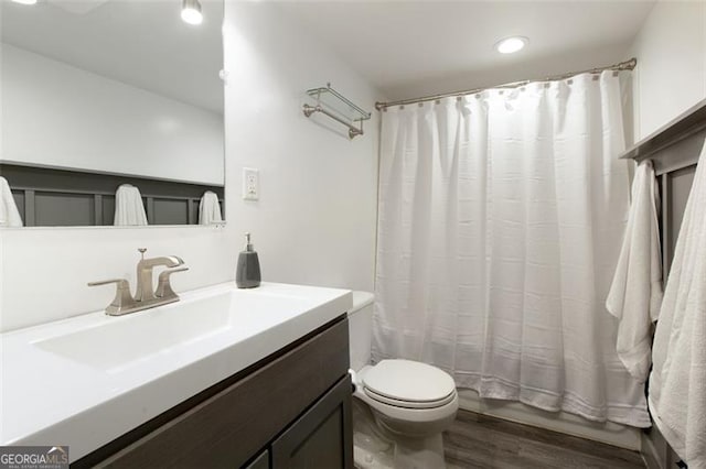 full bathroom with wood-type flooring, vanity, toilet, and shower / bathtub combination with curtain