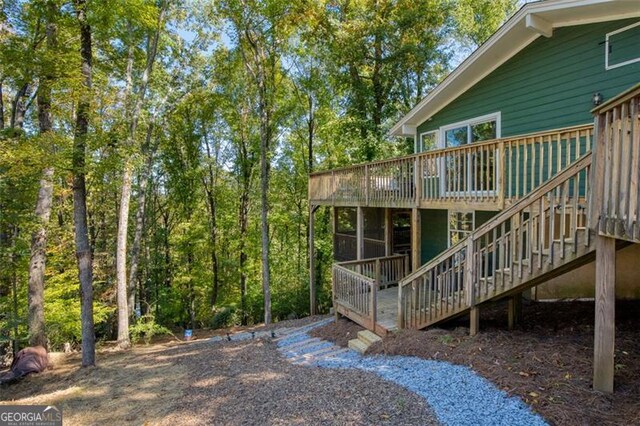 rear view of house with stairway and a deck