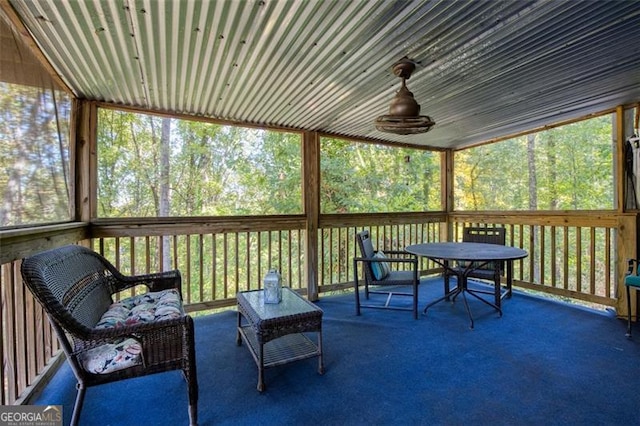 sunroom / solarium with ceiling fan and outdoor dining area