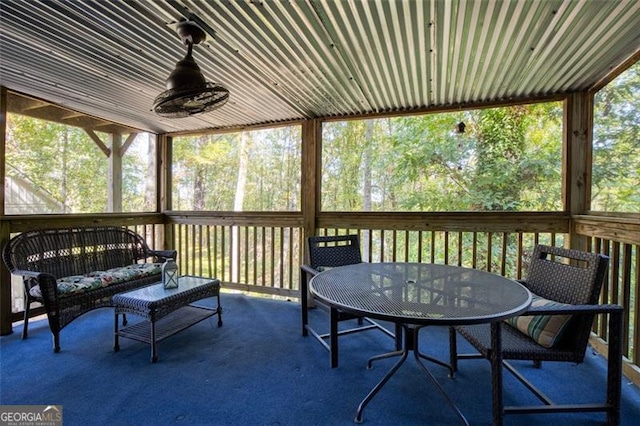 sunroom featuring outdoor dining area and ceiling fan