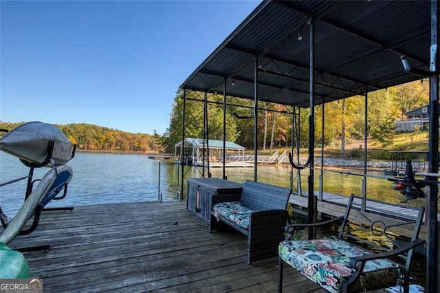 dock area featuring a forest view, a water view, and boat lift