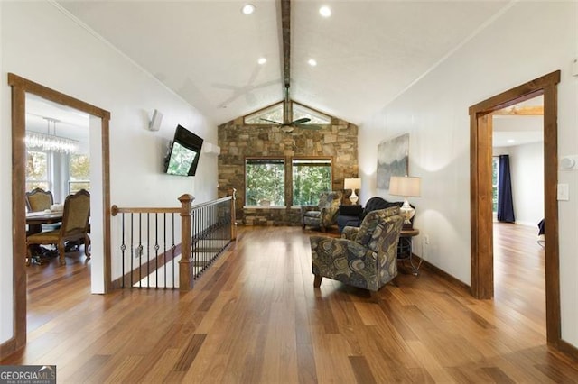 sitting room featuring wood finished floors, vaulted ceiling with beams, and plenty of natural light