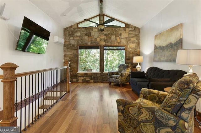 living room with hardwood / wood-style flooring, ceiling fan, and vaulted ceiling