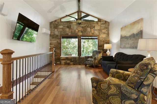 living room with wood-type flooring, lofted ceiling, a ceiling fan, and a healthy amount of sunlight