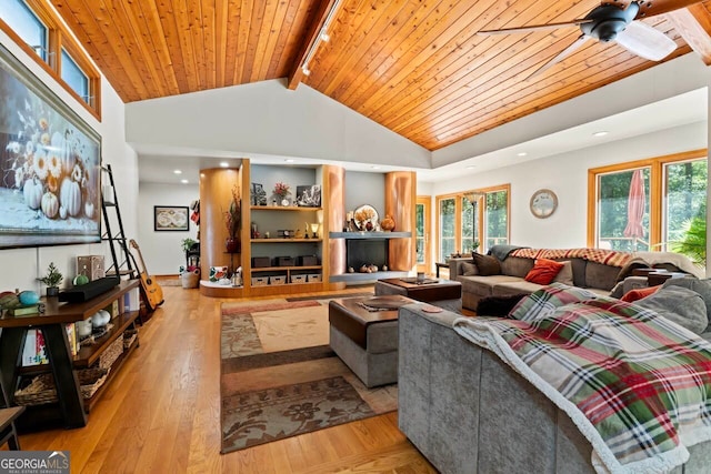 living room with a healthy amount of sunlight, beam ceiling, wood ceiling, and light hardwood / wood-style floors