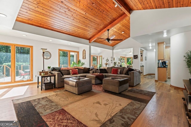 living room with light hardwood / wood-style floors, high vaulted ceiling, beamed ceiling, and plenty of natural light