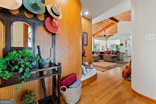 hallway with vaulted ceiling with beams, wood-type flooring, a healthy amount of sunlight, and wooden ceiling