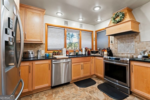 kitchen featuring appliances with stainless steel finishes, premium range hood, tasteful backsplash, and sink