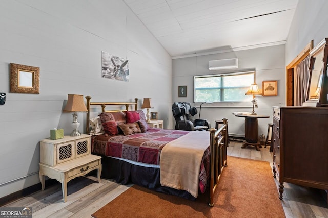 bedroom featuring lofted ceiling, a wall mounted AC, and light wood-type flooring