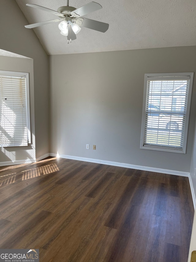 unfurnished room featuring dark wood-type flooring, ceiling fan, a textured ceiling, and lofted ceiling